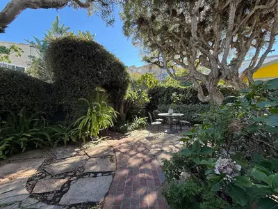a patio with a table and a bench in a garden at Venice Beach Townhouse in Los Angeles