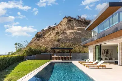 a swimming pool in front of a house with a mountain at Luxurious Malibu 6BR Estate with Pool, Theatre, Views in Malibu Beach