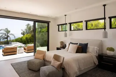 a bedroom with a bed and a couch and windows at Malibu Coastal Paradise with Pool, Spa and Tennis Court in Malibu