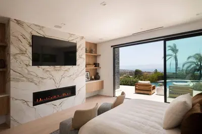 a bedroom with a fireplace and a tv on a wall at Malibu Coastal Paradise with Pool, Spa and Tennis Court in Malibu