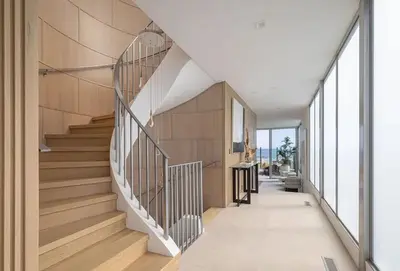 a winding staircase in a house with wooden walls at Luxury Beachfront Villa W. Stunning Pacific Views in Malibu