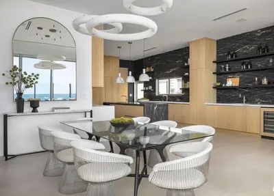 a dining room with a glass table and white chairs at Luxury Beachfront Villa W. Stunning Pacific Views in Malibu