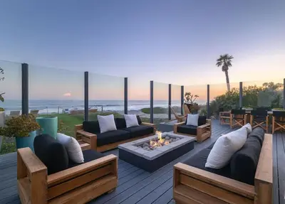 a patio with couches and a fire pit and the ocean at Luxury Beachfront Villa W. Stunning Pacific Views in Malibu