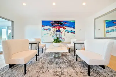 a room with tables and chairs and a painting at Stunning Modern Estate in BH with Pool, Spa, and Views in Los Angeles