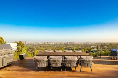 a table and chairs on a deck with a view at Stunning Modern Estate in BH with Pool, Spa, and Views in Los Angeles