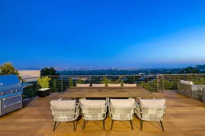 a patio with a table and chairs on a balcony at Stunning Modern Estate in BH with Pool, Spa, and Views in Los Angeles