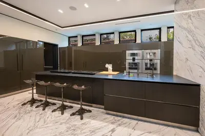 a large kitchen with a counter with bar stools at Ultra Luxurious Villa in the Beverly Hills Flats in Los Angeles