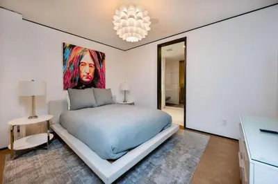 a bedroom with a bed with a painting on the wall at Ultra Luxurious Villa in the Beverly Hills Flats in Los Angeles