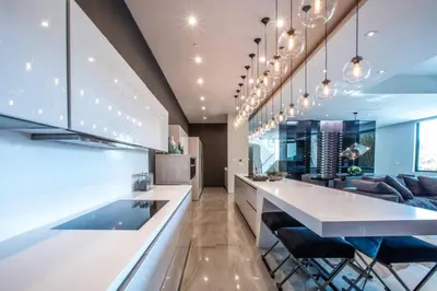 a kitchen with a large white counter and chairs at Beverly Hills Luxurious 4BR Villa with Pool and Views in Los Angeles