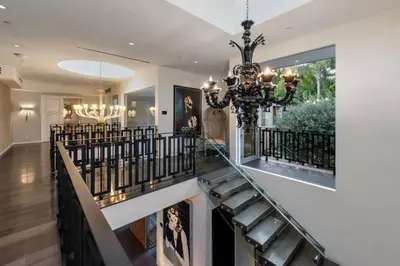 a staircase in a home with a chandelier at Royalty Villa in Beverly Hills in Los Angeles