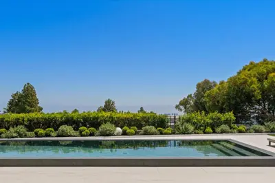 a swimming pool in a garden with a bench at Ultra Luxurious 5BR Villa W. Pool, Jacuzzi, Views in Los Angeles