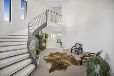 a staircase in a house with a rug on the floor at Prestigious Hillside Villa W. Pool, Theater, Views in Los Angeles
