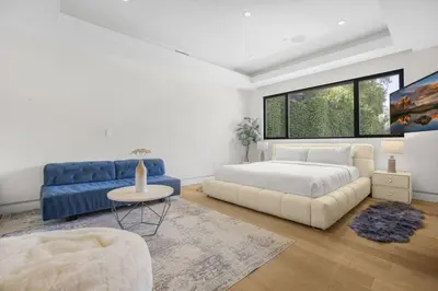 a bedroom with a bed and a blue couch at Prestigious Hillside Villa W. Pool, Theater, Views in Los Angeles