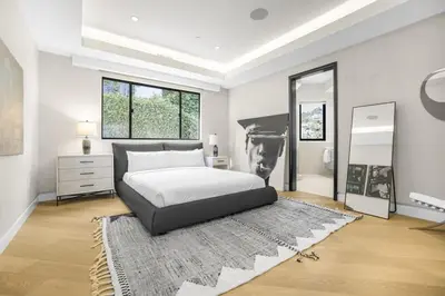 a bedroom with a bed with a black and white photo on the wall at Prestigious Hillside Villa W. Pool, Theater, Views in Los Angeles