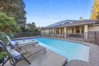 a swimming pool with a bench and a house at Corporate & Family Retreat Seven Oaks Pool Home in Bakersfield