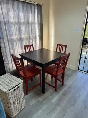 a dining room table with four chairs and a window at 262 Coronado ave in Long Beach