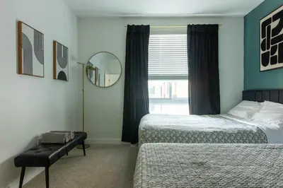 a bedroom with two beds and a mirror and a window at Modern Serenity Apartment for a Comfortable Stay in Glendale