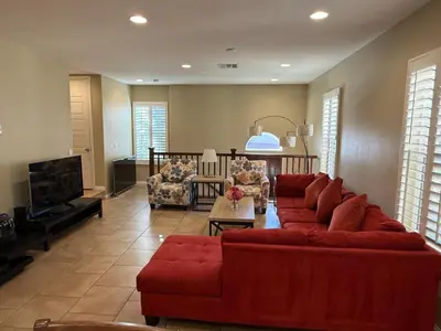 a living room with a red couch and a tv at Shopping at Arcadia Mall, Homes, School District, Comfortable Home on Huntington Road in Arcadia
