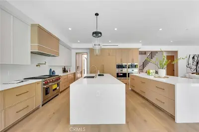 a large kitchen with white countertops and wooden cabinets at Studio City Luxury 6BR Home with Pool and Theatre in Los Angeles