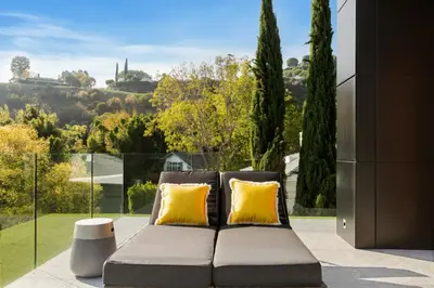 a couch with two yellow pillows sitting on a patio at Belfast Estate in Los Angeles