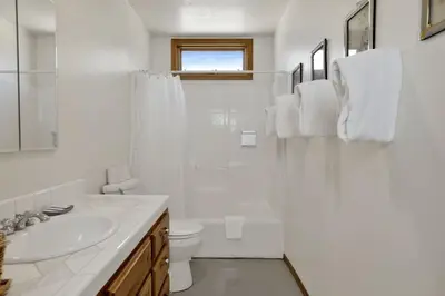 a white bathroom with a sink and a toilet at The Village Timber Lodge at Big Bear - Downtown Log Cabin Retreat in Big Bear Lake