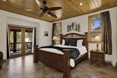 a bedroom with a bed and a ceiling fan at The Village Timber Lodge at Big Bear - Downtown Log Cabin Retreat in Big Bear Lake