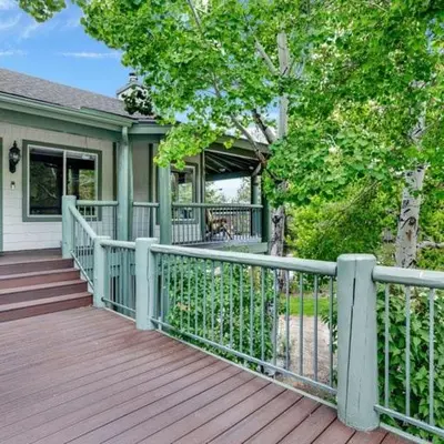 a house with a wooden deck with a fence at Modern Relaxation at Castle Glen Gem Big Bear Lake in Big Bear Lake