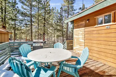 a table and chairs on the deck of a cabin at Vista Pines at Big Bear Lake– Your Ultimate Mountain Escape in Big Bear Lake