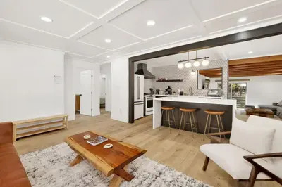 a living room with a table and a kitchen at Vista Pines at Big Bear Lake– Your Ultimate Mountain Escape in Big Bear Lake