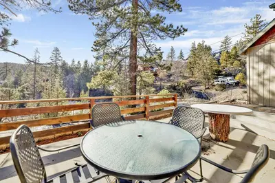 a table and chairs on a patio with a view at Pleasant Pause Family Retreat in Big Bear Lake in Fawnskin