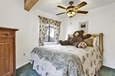 a teddy bear sitting on a bed in a bedroom at Pleasant Pause Family Retreat in Big Bear Lake in Fawnskin