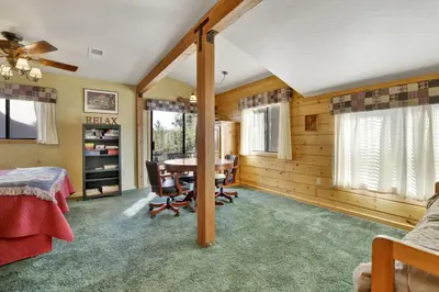 a bedroom with a table and chairs in a room at Pleasant Pause Family Retreat in Big Bear Lake in Fawnskin