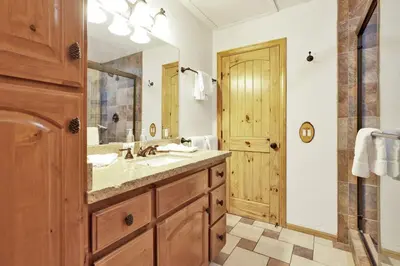 a bathroom with a sink and a large mirror at Pleasant Pause Family Retreat in Big Bear Lake in Fawnskin
