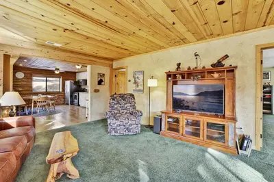 a living room with a television and a couch and a table at Pleasant Pause Family Retreat in Big Bear Lake in Fawnskin