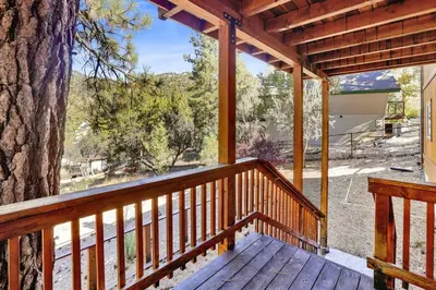a wooden porch with a large tree on it at Lookout Lodge Family Chalet at Big Bear w/ Games in Big Bear City