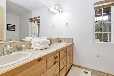 a bathroom with a tub and a sink and a mirror at Lookout Lodge Family Chalet at Big Bear w/ Games in Big Bear City