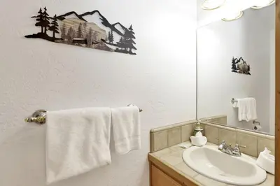 a bathroom with a sink and a mirror at Lookout Lodge Family Chalet at Big Bear w/ Games in Big Bear City