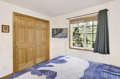 a bedroom with a bed and a door and a window at Lookout Lodge Family Chalet at Big Bear w/ Games in Big Bear City