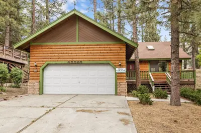 a wooden house with a garage in front of it at Pines & Needles Mountain Retreat by Big Bear Vacations in Big Bear Lake