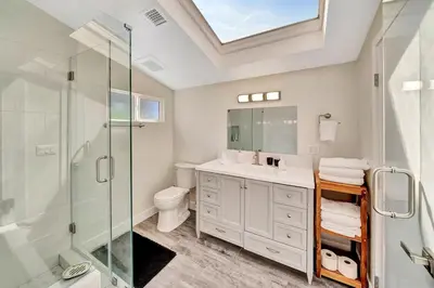 a bathroom with a shower and a toilet and a sink at Incredible View, Huge Pool & Basketball! in Tarzana