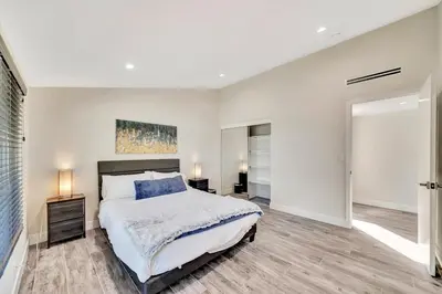 a bedroom with a large bed and a mirror at Incredible View, Huge Pool & Basketball! in Tarzana