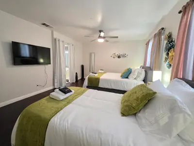 a hotel room with two beds and a flat screen tv at Newly Listed Family Friendly Fontana House in Fontana
