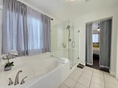 a white bathroom with a tub and a shower at Newly Listed Family Friendly Fontana House in Fontana