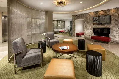a lobby with chairs and a table and a fireplace at Hotel Aventura in Los Angeles