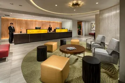 a lobby of a hotel with a man standing at a counter at Hotel Aventura in Los Angeles