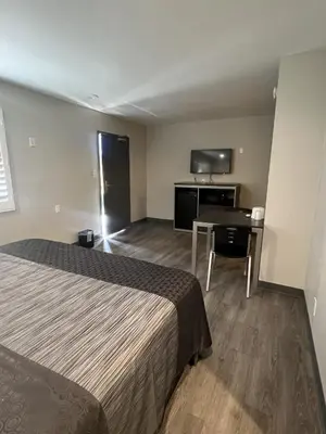 a hotel room with a bed and a desk at Cloud 9 Inn - El Ciello Inn in Pico Rivera