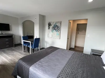 a hotel room with a bed and a table and chairs at Cloud 9 Inn - El Ciello Inn in Pico Rivera