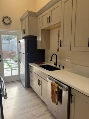 a kitchen with white cabinets and a sink and a refrigerator at Perfect and relaxing Couple retreat in the heart of Los Angeles in Los Angeles