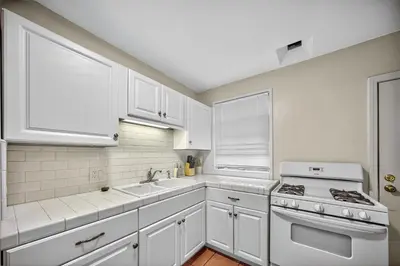 a white kitchen with a stove and a sink at Luxury Cozy 2BR 1BA near LAX, LMU, SoFi Stadium, Beach in Los Angeles