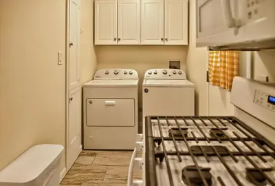 a kitchen with white cabinets and a stove top oven at Cozy Modern 2BR 1BA near LAX, LMU, SoFi Stadium and the Beach in Los Angeles